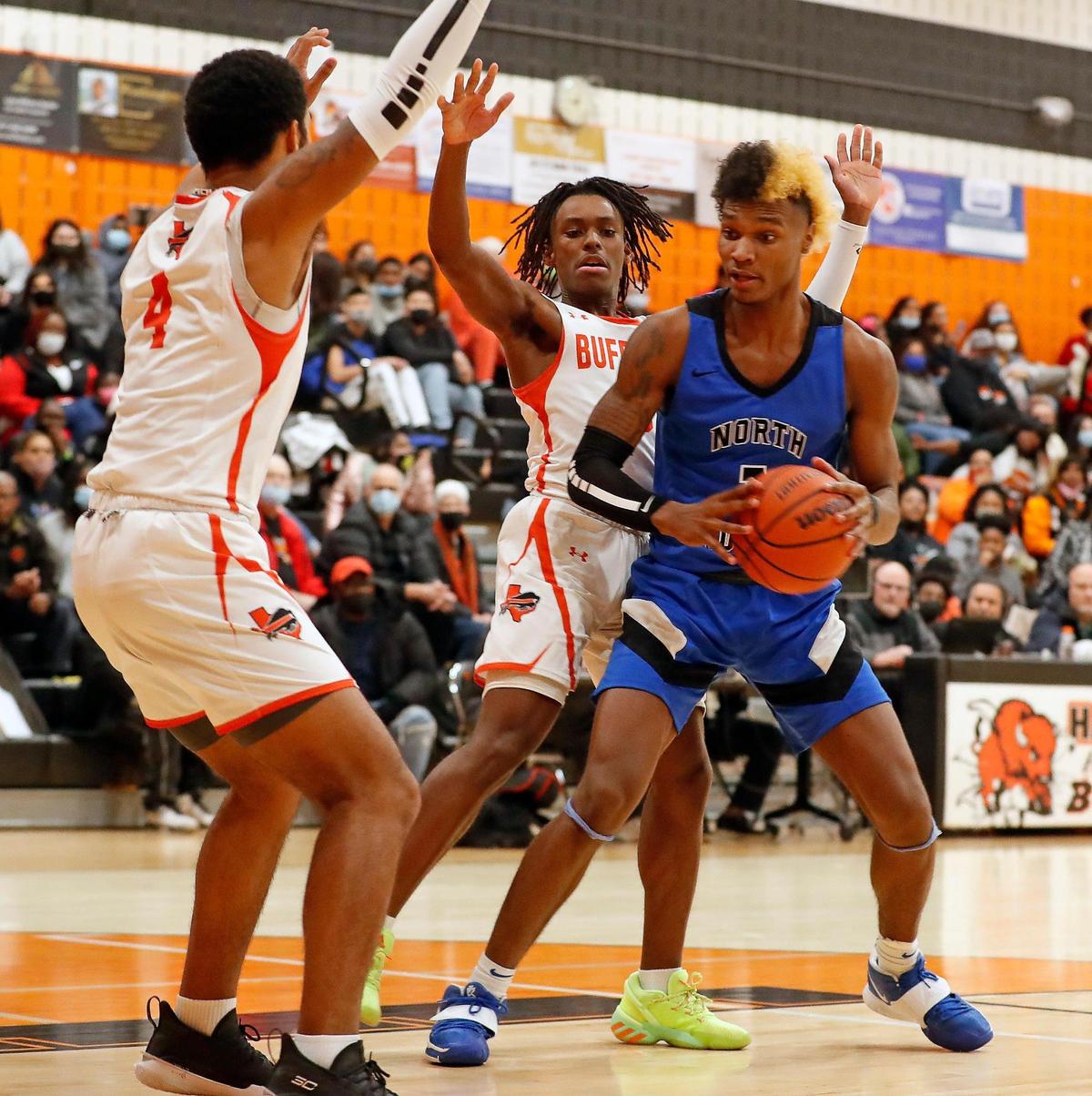 North Crowley wing Marques Sales (1) gets a shot off defend by Haltom forward Jace Washington (4) and guard Quincy Haggerty (3) during a District 3-6A Bi-district basketball game at Haltom High School in Haltom City, Texas, Friday, Feb. 12, 2021. North Crowley defeated Haltom 55-45. (Special to the Star-Telegram Bob Booth)