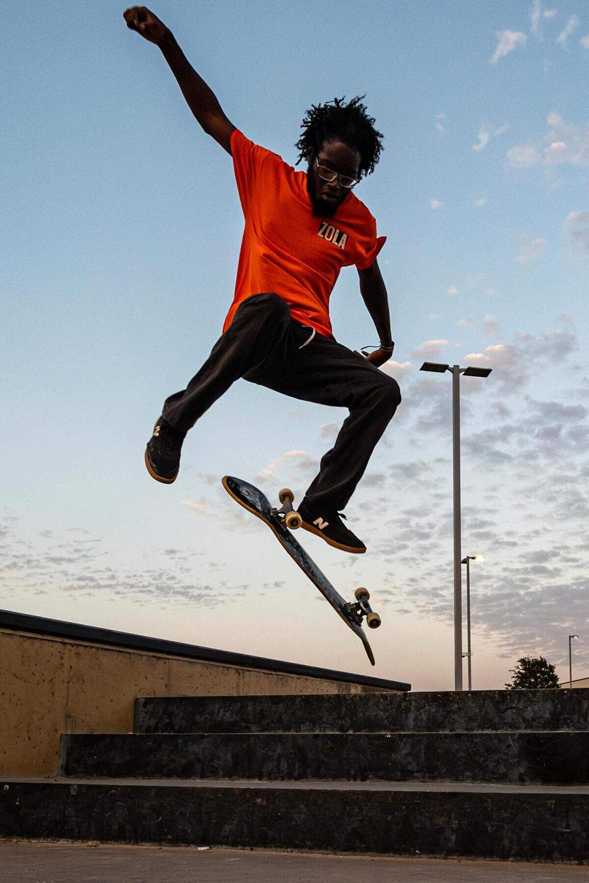 Donald Sanford does a kick flip off the steps at sunset at Chisholm Trail Skate Park in Fort Worth on Tuesday, Aug. 29, 2023.