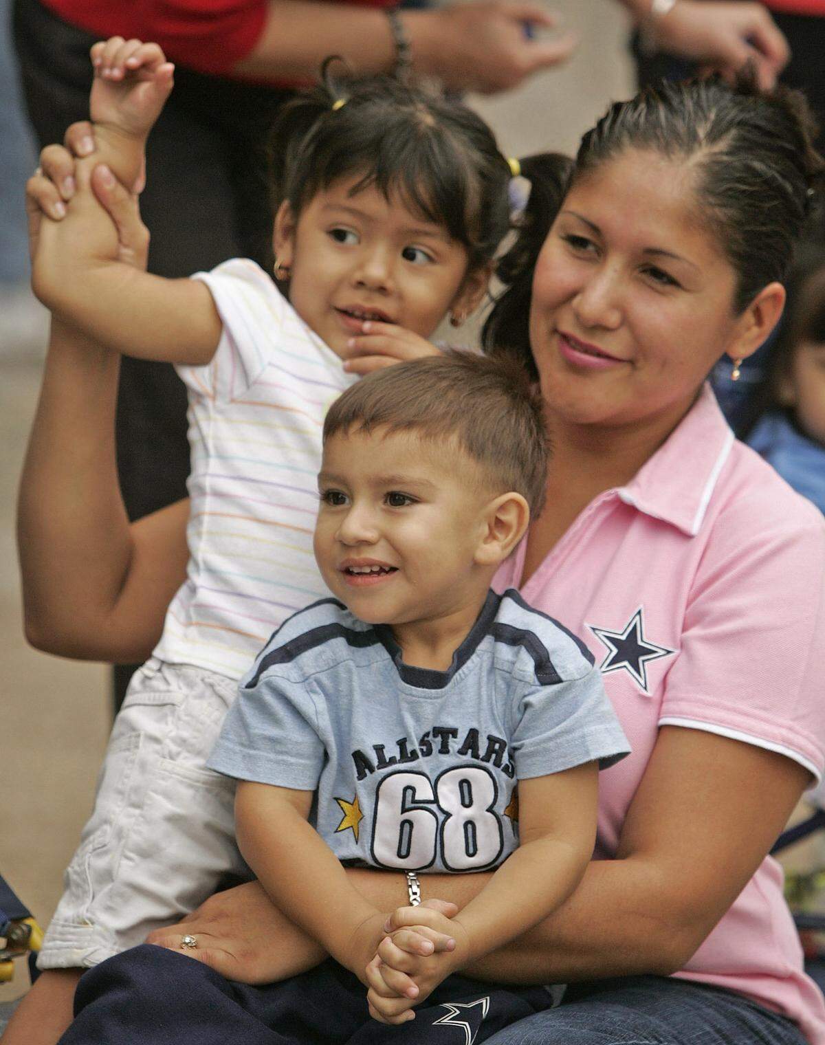 Sept. 30, 2005: Narda Mendoza holds her nephew, Israel Reyna, 2, in her lap and her daughter, Natalie Mendoza, by her side as the State Fair of Texas parade makes its way up Main Street in Dallas. The Texas State Fair was in its 119th season.