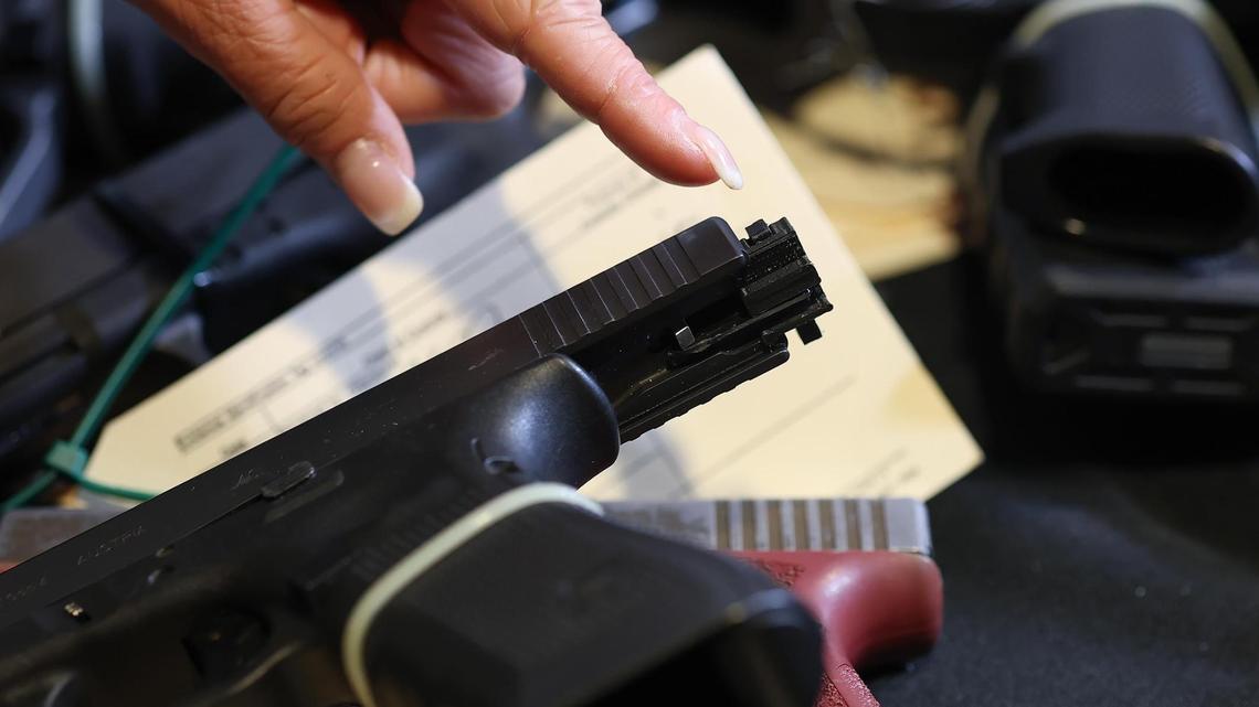 Sara Abel, the public information officer for the Bureau of Alcohol, Tobacco, Firearms and Explosives (ATF) Dallas Field Division, points out a machine gun conversion device on a pistol during a press conference on Wednesday, June 18, 2025, in Fort Worth.