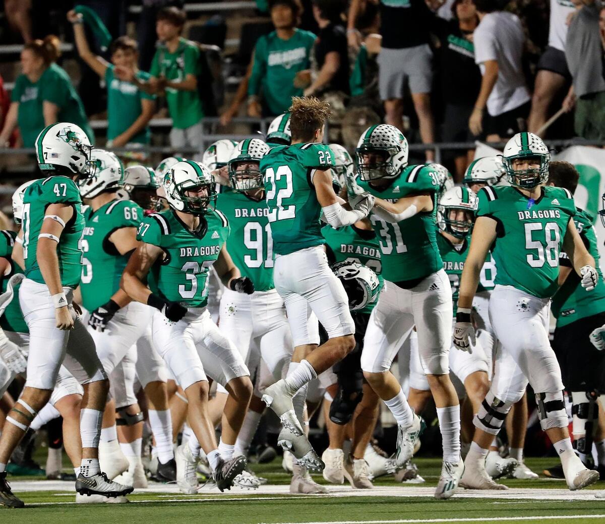 Southlake Carroll defensive back Logan Lewandowski (22) celebrates with defensive back Cole Carter (31) after intercepting a pass to seal the game in the second half of a District 4-6A high school football game at Dragon Stadium in Southlake, Texas, Friday, Oct. 07, 2022. Carroll defeated Keller 38-35. (Special to the Star-Telegram Bob Booth)