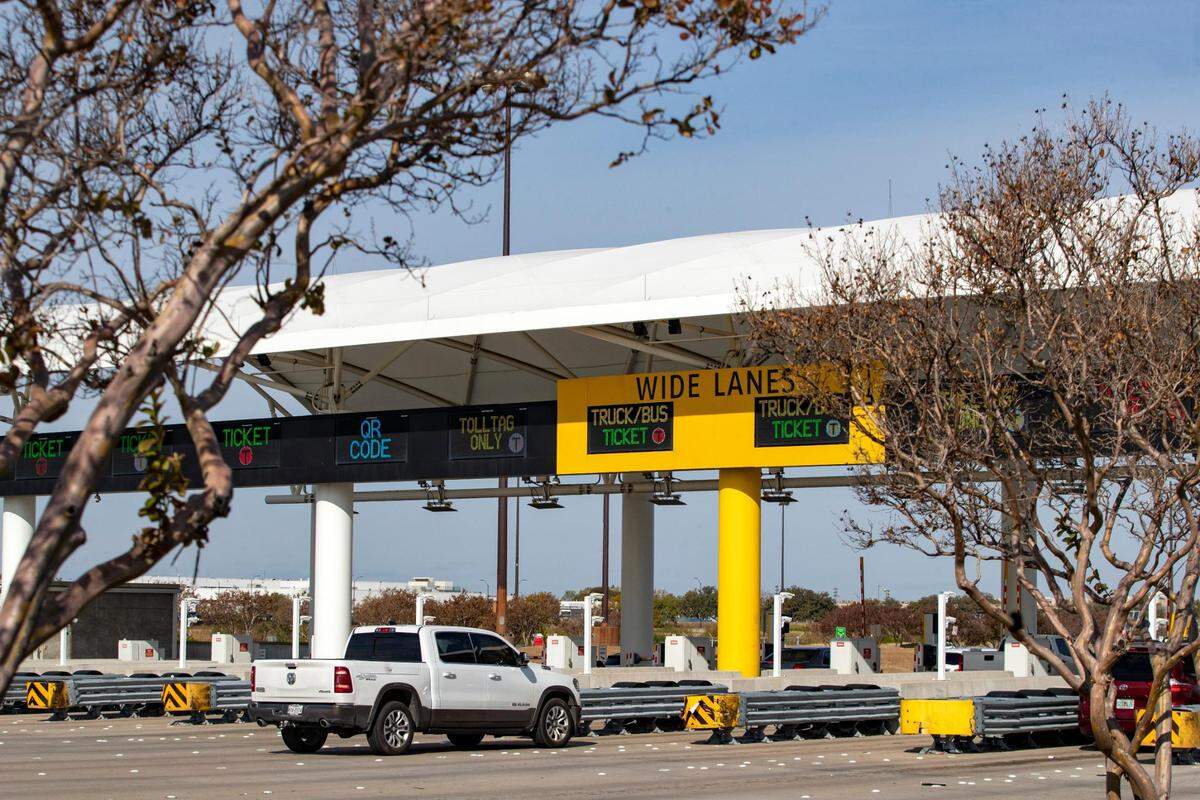 Cars drive through the toll booth at the Dallas Fort Worth International Airport on Friday, Nov. 18, 2022.