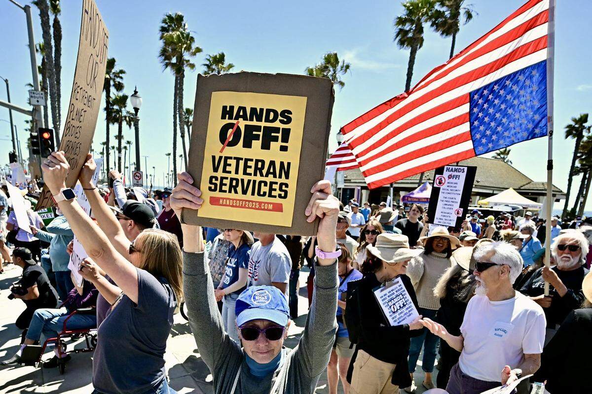 Demonstrators rally during the nationwide “Hands Off!” protest against President Donald Trump and his advisor, Tesla CEO Elon Musk, on April 5, 2025, in Huntington Beach, California.