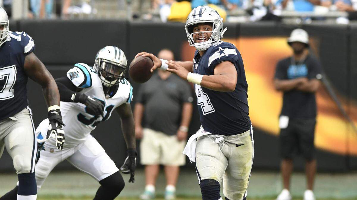 Dallas Cowboys quarterback Dak Prescott (4) rolls out to pass as he gets pressure from the Carolina Panthers defense on Sunday, Sept. 9, 2018 at Bank of America Stadium in Charlotte, N.C.