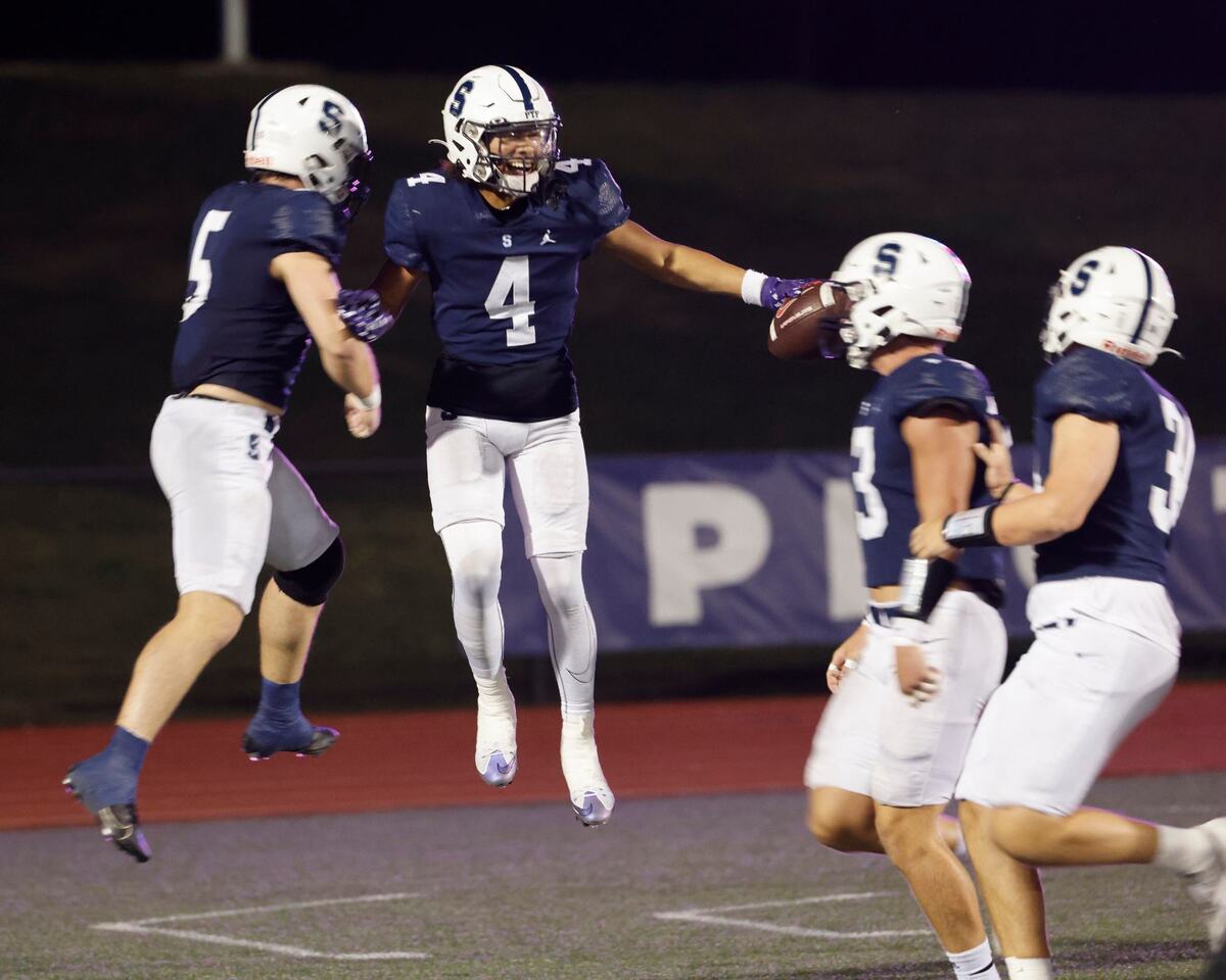 All Saints linebacker Keyon Adkins (4) celebrates with team mates after his pick six during a TAPPS football game at All Saints High School’s McNair Stadium in Fort Worth Thursday, Sept. 12, 2024.