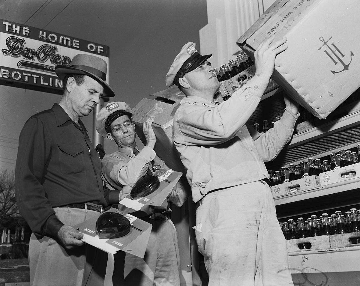 Feb. 2, 1952: “Bill Estill, the Dr. Pepper Bottling Co. sales manager, holds a pair of heart campaign collection boxes which his route men will install at more than 800 business places. At left is Frank Carrico, route superintendent, and Sherman Sitton, salesman is at right.”