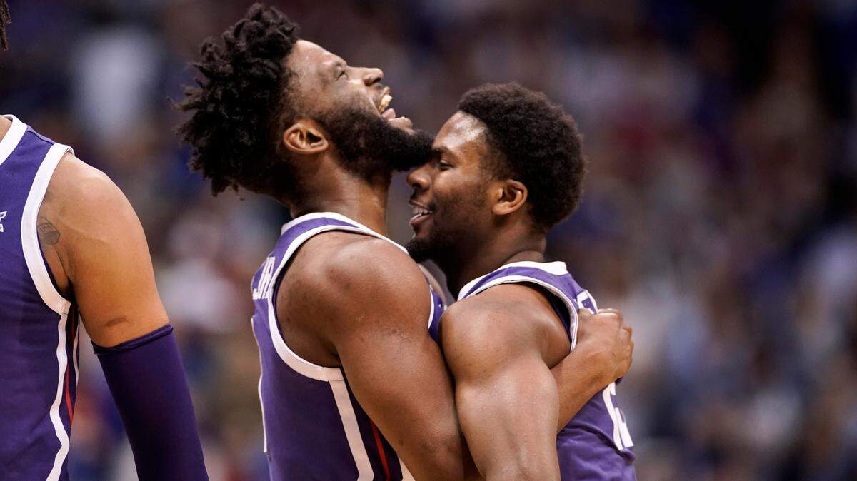 TCU guards Mike Miles Jr., left, and Shahada Wells (13) embrace during a timeout in the first half of an NCAA college basketball game against Kansas on Saturday, Jan. 21, 2023, at Allen Fieldhouse in Lawrence, Kan. (AP Photo/Nick Krug)