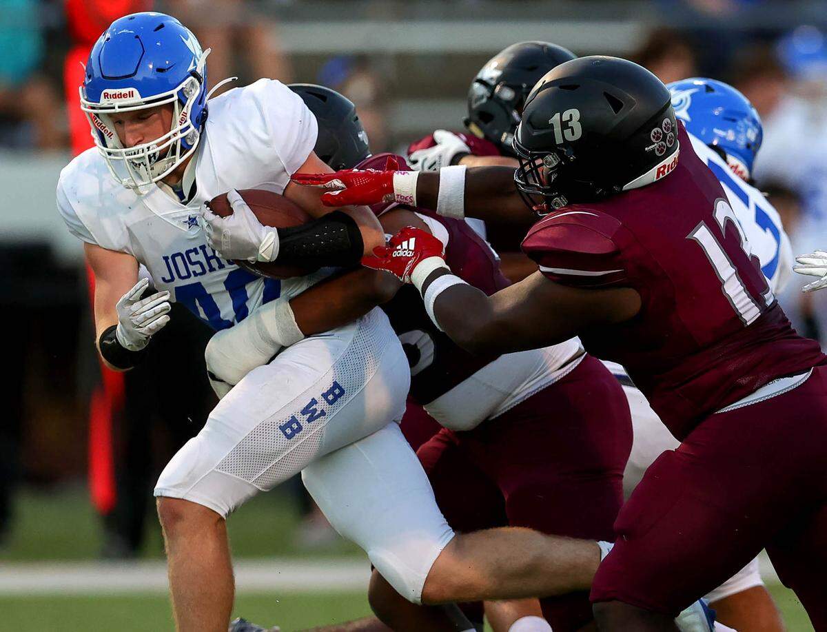 Joshua running back Kolby Smith (40) gets stopped for a loss by Mansfield Timberview linebacker Kye Nash (13) and defensive tackle Bryan Mitchell during the first half, Thursday night, September 23, 2021 played at Newsom Stadium in Mansfield, TX. (Steve Nurenberg Special to the Star-Telegram)
