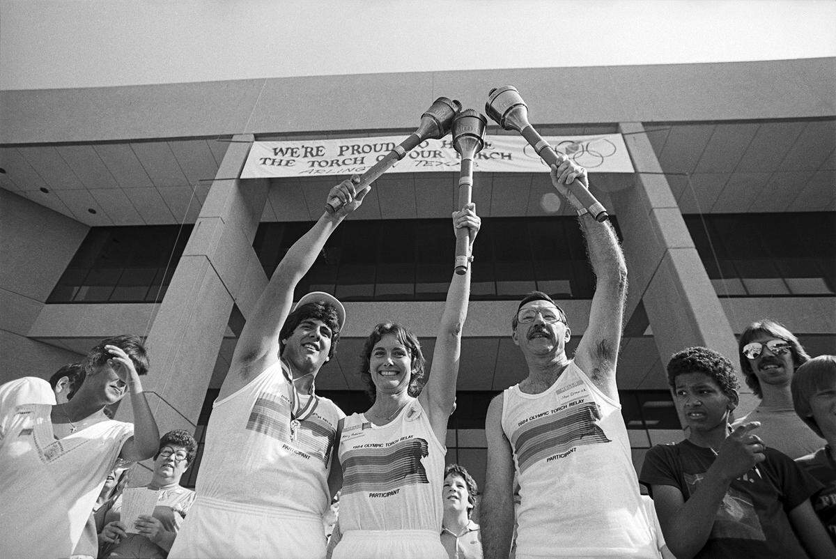 1984 Olympic Torch relay team runners posed in front of Arlington City Hall are, from left, Kevin Procaccino, Nancy Anderson, and Stan Dimmick.