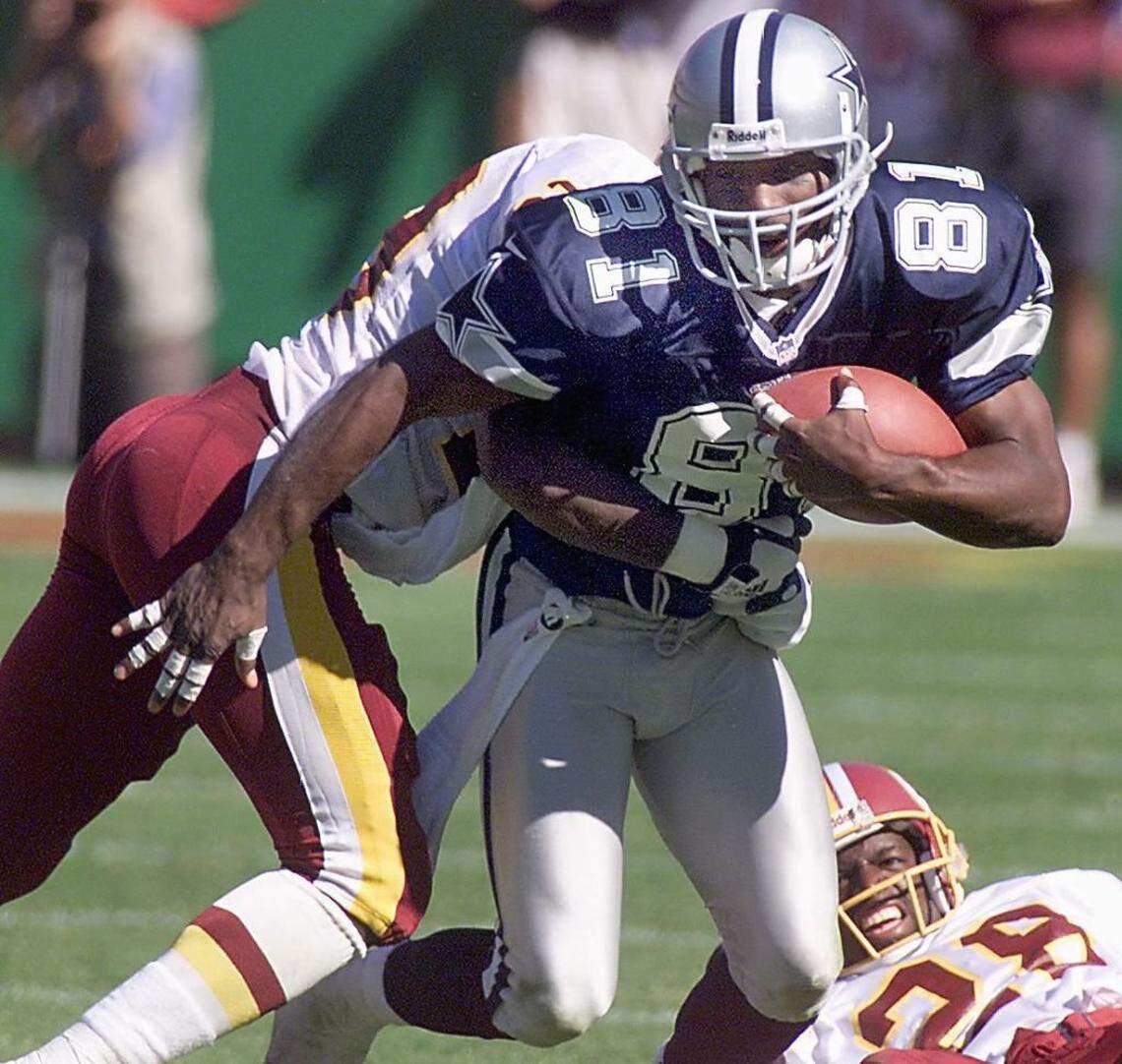 Dallas Cowboys wide receiver Raghib Ismail rushes through two Redskin defenders at Jack Kent Cooke Stadium 12 September, 1999, Landover, Maryland. Ismail caught the winning touch down pass in overtime to beat the Redskins 42-35. (ELECTRONIC IMAGE) Tim Sloan/AFP PHOTO (Photo by Tim SLOAN / AFP) (Photo by TIM SLOAN/AFP via Getty Images)