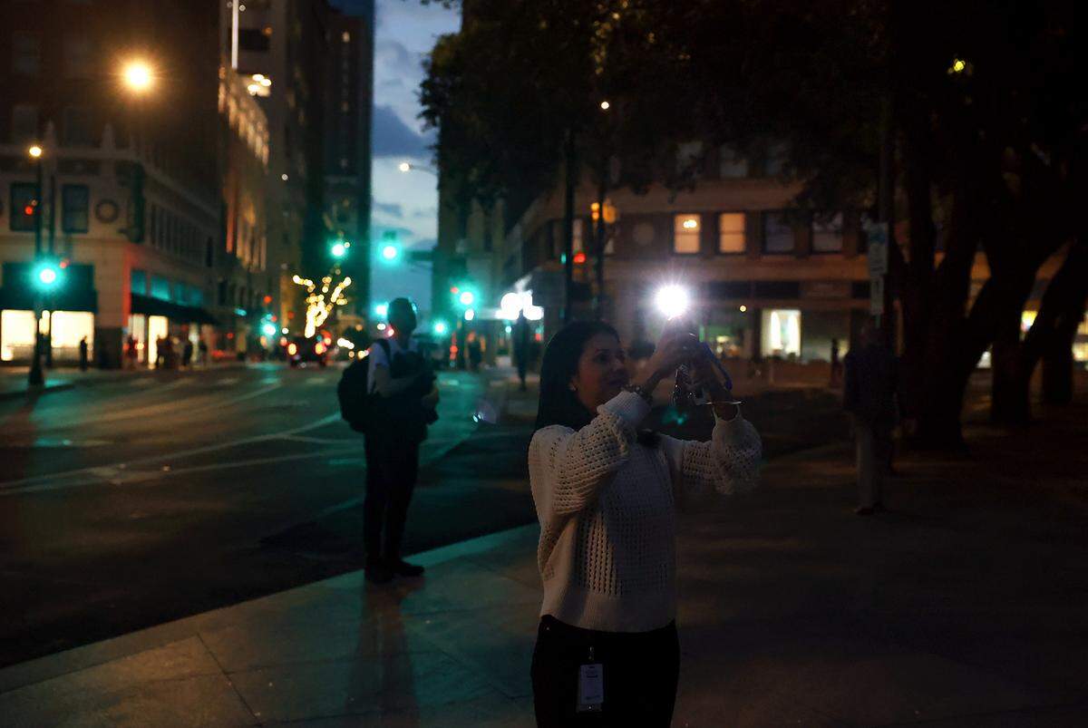 People watch the full solar eclipse near Burnett Park in downtown Fort Worth on Monday, April 8, 2024.