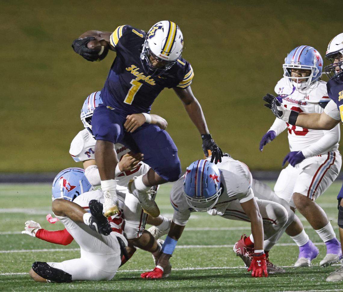 Fort Worth Arlington Heights running back Carson James (1) leaps the pile on the way to the end zone for one of his three touchdowns during the first half of a UIL Class 5A DI area-round football playoff game Thursday Nov. 20, 2025 at Shotwell Stadium in Abilene, Texas.