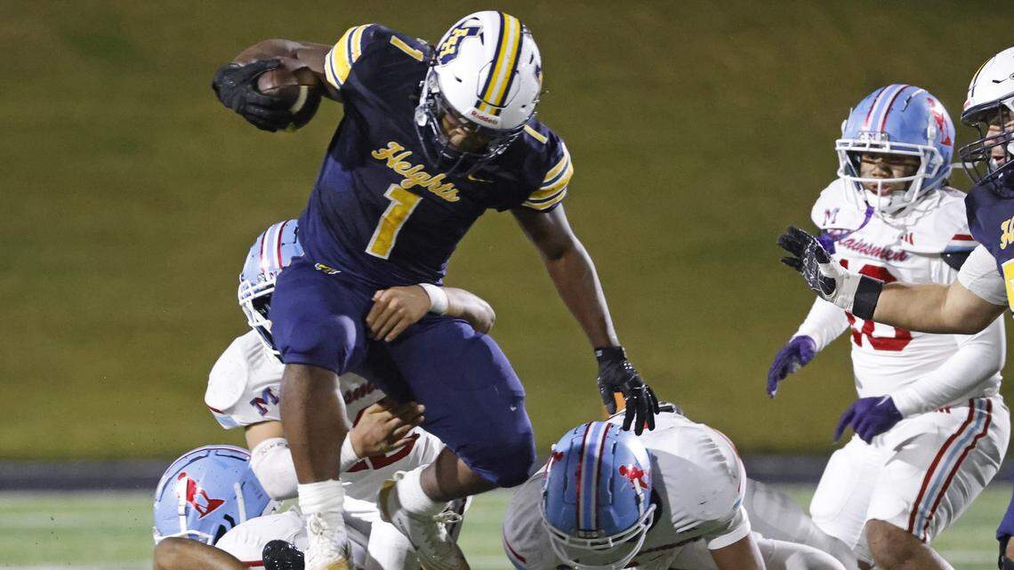Fort Worth Arlington Heights running back Carson James (1) leaps the pile on the way to the end zone for one of his three touchdowns during the first half of a UIL Class 5A DI area-round football playoff game Thursday Nov. 20, 2025 at Shotwell Stadium in Abilene, Texas.