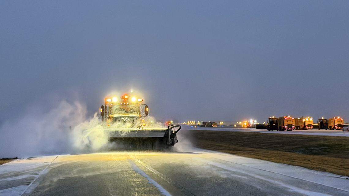 A plow removes ice and sleet at Dallas-Fort Worth International Airport early Saturday, Jan. 24. The majority of scheduled flights for the day have been canceled, but the airport remains operational.