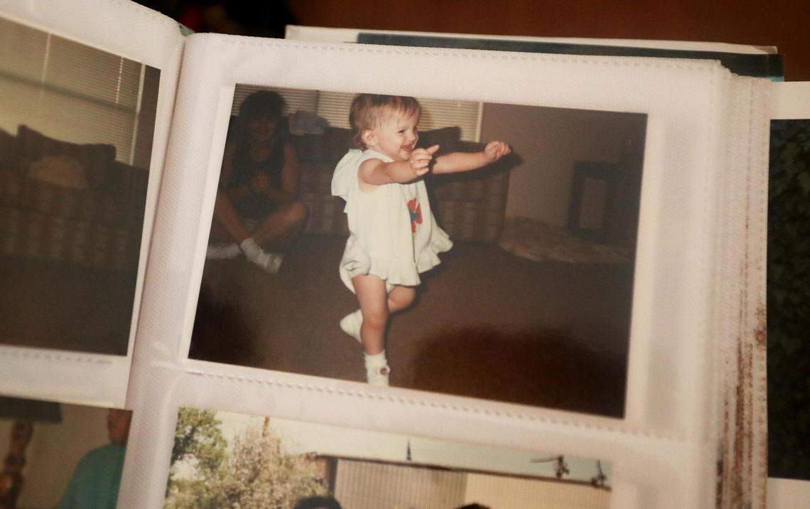 A page in a photo album shows a photograph of Lauren Phillips as a young child taking her first steps. Kathie Phillips, Lauren’s mother, says she was a lively child who enjoyed the outdoors but as she grew up she became troubled and battled with addiction.