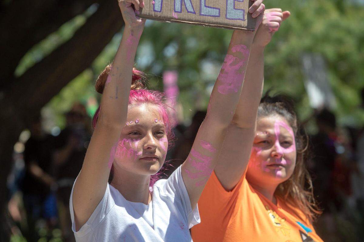 Corrianna and Stephanie Cox face cars driving by the Bans Off Our Bodies protest at the Tarrant County Courthouse on Saturday, June 25, 2022, in Fort Worth, Texas. Hundreds of abortion-rights advocates gathered at the steps of the courthouse before marching downtown.