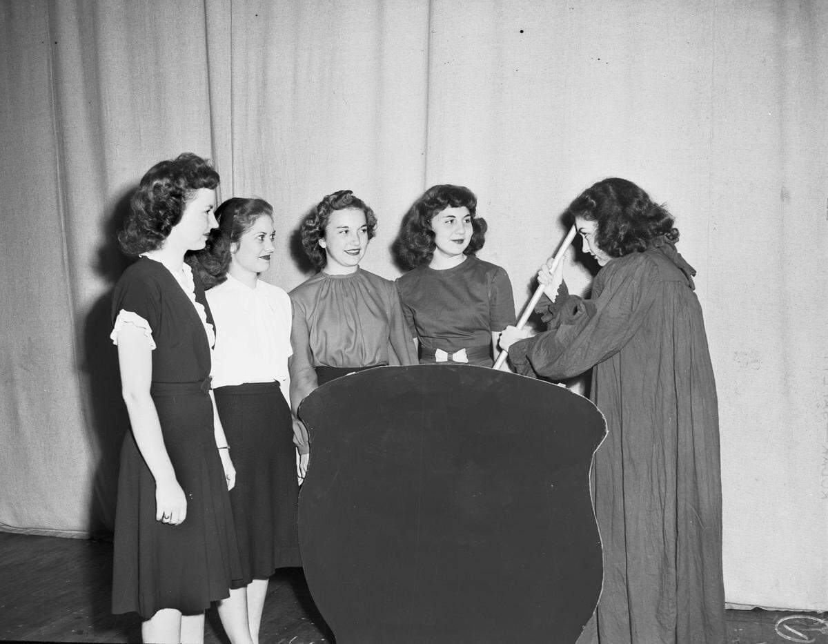 Oct. 31, 1946: Texas Wesleyan College’s Halloween carnival. Carolyn Clark (right), junior from Ranger, is playing the role of “wicked old witch”. She is shown stirring her brew before deciding that Jeanne Johnson, fourth from left, freshman from Riesel, be crowned as queen of the 1946 Halloween carnival. Others are, left to right, Jo Ann Gunn, senior from Granbury; Deanie Archer, junior from Granbury; and Margaret Hailey, sophomore from Cisco.