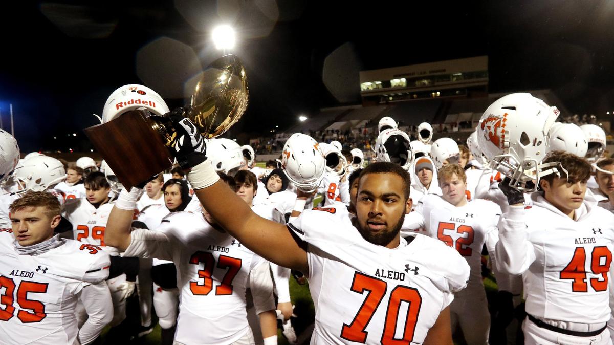 Aledo center Logan Escamilla (70) holds the trophy as the school song is sung after a high school 5A Division II Quarter Finals football playoff game at Northwest ISD Stadium, Justin, Texas, Saturday, Dec. 08, 2018. Aledo handed Frisco Reedy their first loss of the season at 26-16. (Star-Telegram Bob Booth)