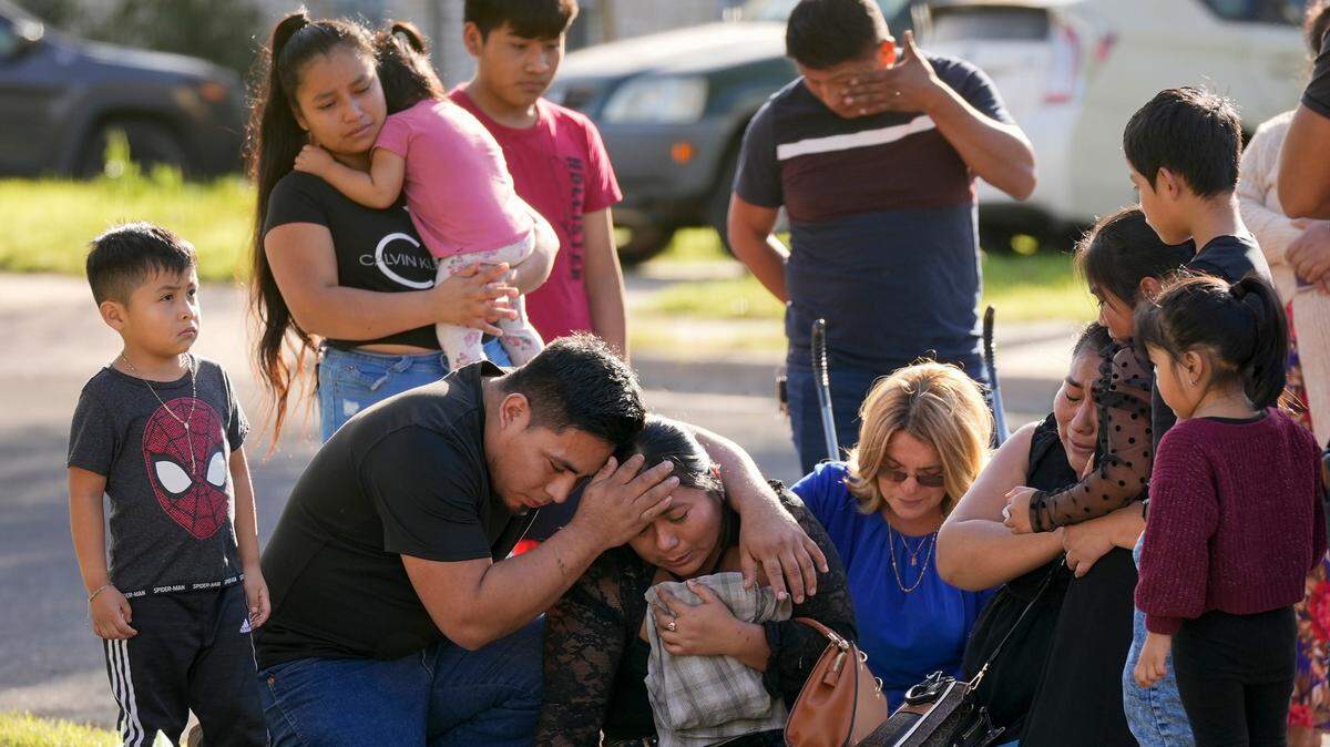 Domatilia Caal, center, is consoled by her brother, Cornelio, on Wednesday, Dec. 6, 2023, in Austin, Texas, at the site where her husband was killed in a violent trail of separate attacks on Tuesday.