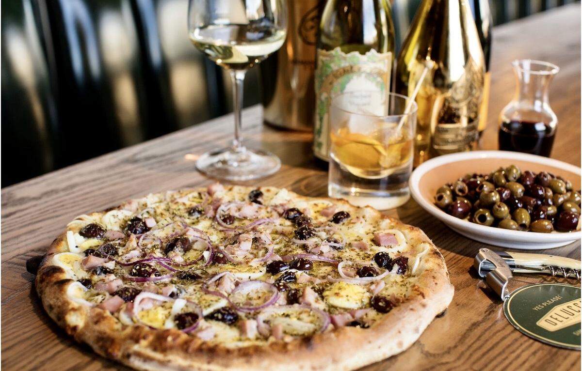A Portuguese pizza with prosciutto cotto, olives, onions hardboiled eggs, oregano and olive oil at Delucca Gaucho Pizza.
