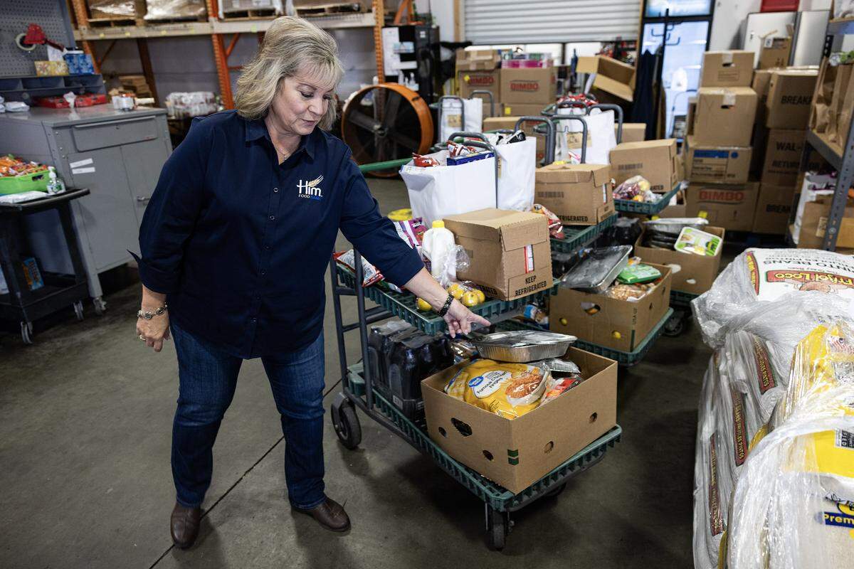 Lisa Richardson, the President and Chief Executive Officer of Him Food Bank, looks through the groceries being given to people in need at Him Food Bank Warehouse in Mansfield on Wednesday, Dec. 3, 2025.