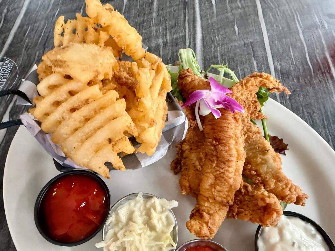 A fried catfish platter with waffle fries at Johnny’s World Famous Chicken and Waffles May 2, 2025, in Dallas, Texas.