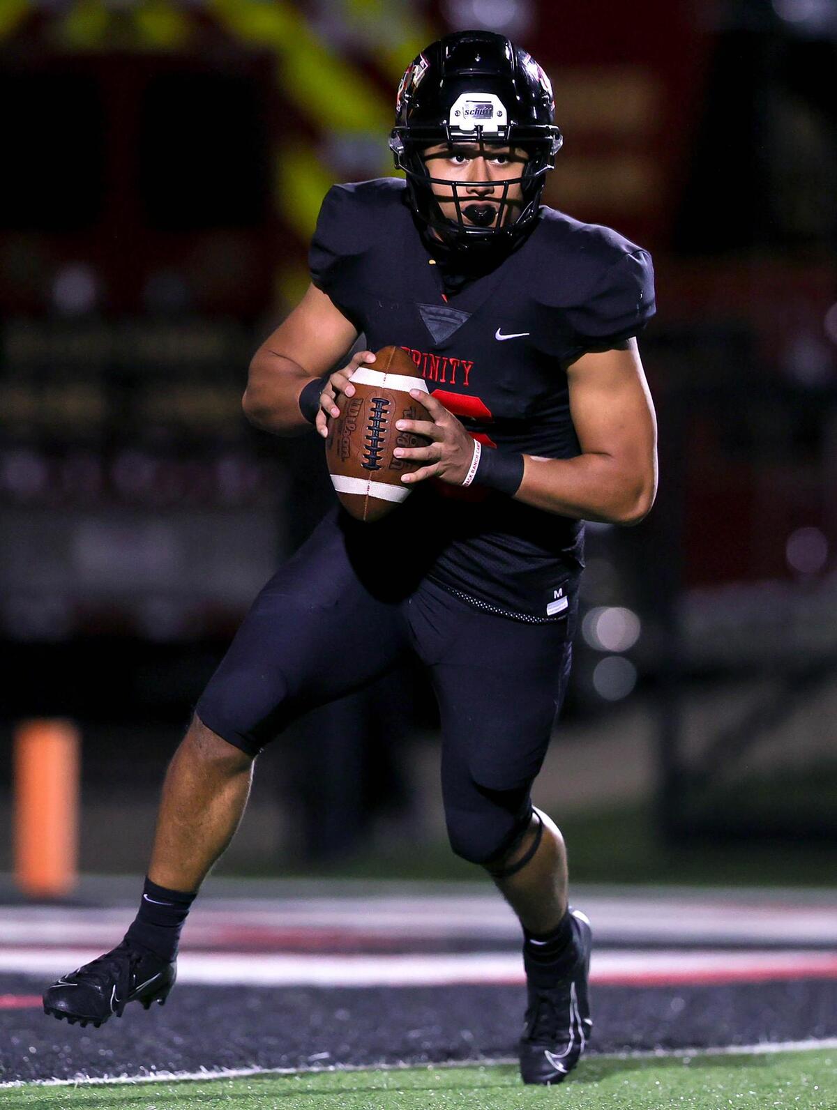 Trinity quarterback Valentino Foni rolls out to pass against North Crowley during the first half of a high school football game, Thursday night, November 5, 2020 played at Pennington Field in Bedford, Tx. (Steve Nurenberg Special to the Star-Telegram)