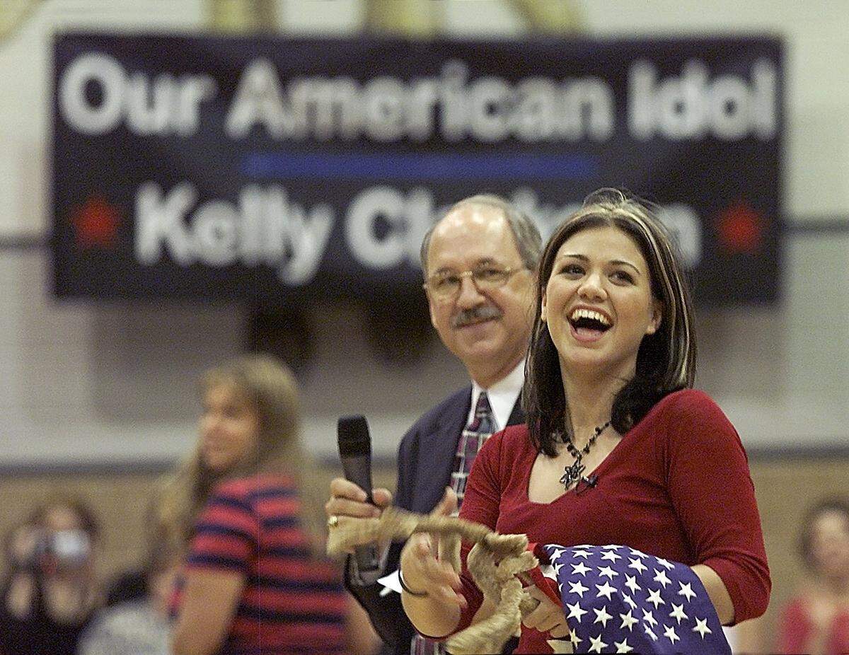 Kelly Clarkson, right, is greeted by the student body in the gymnasium at Burleson High School on Thursday  August 22, 2002.   With her is school principal Richard Crummel.