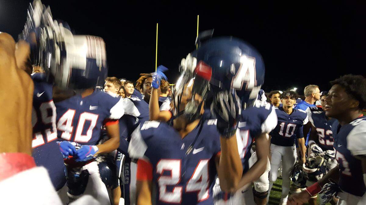 Allen senior Saivon Gordon holds up his helmet as the Eagles celebrate their 52-40 win over Rockwall on Friday.