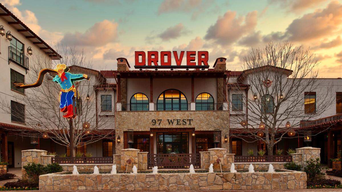 The 97 West entrance has a neon cowboy under the old-time “Drover” sign.