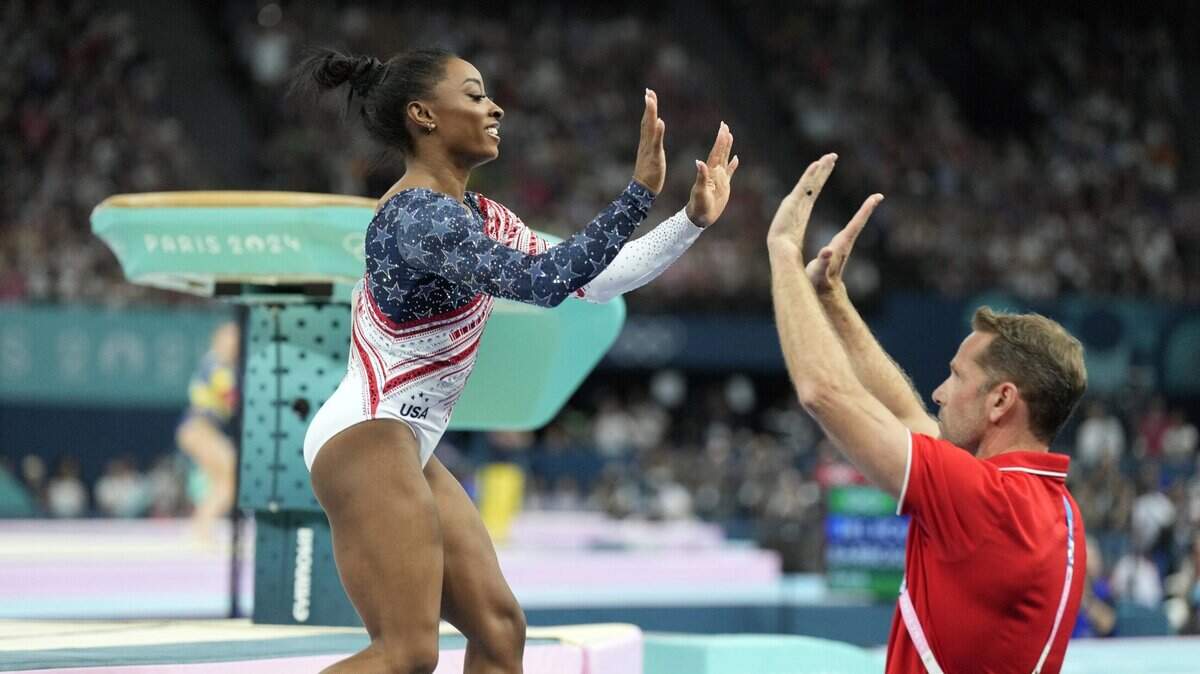 Simone Biles of the United States high fives coach Laurent Landi after competing on the vault during the women’s team final at the Paris 2024 Olympic Summer Games at Bercy Arena. 