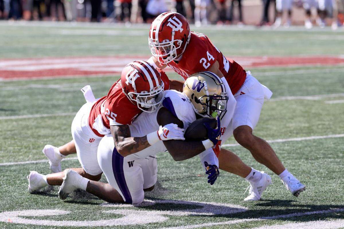 BLOOMINGTON, INDIANA - OCTOBER 26: Jonah Coleman #1 of the Washington Huskies is tackled by Amare Ferrell #25 and Bryson Bonds #24 of the Indiana Hoosiers during the first quarter at Memorial Stadium on October 26, 2024 in Bloomington, Indiana. (Photo by Justin Casterline/Getty Images)