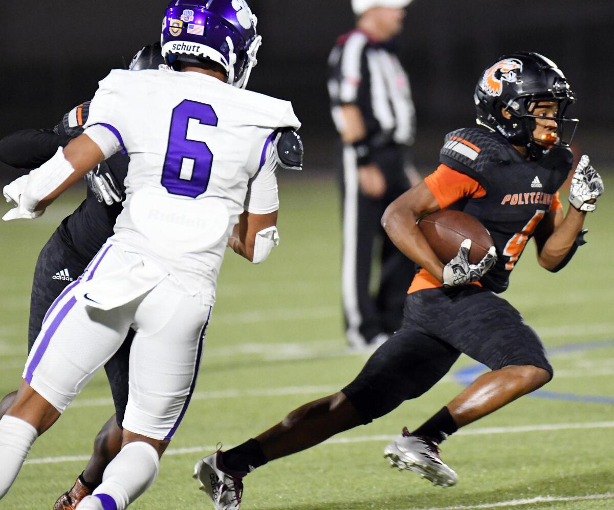 Paschal’s Austin Cunningham, left watches as Polytechnic’s Edward Blanton races for a first down in the second quarter of their football game Thursday, October 8, 2020 at Clark Stadium in Fort Worth, Texas. Special/Bob Haynes