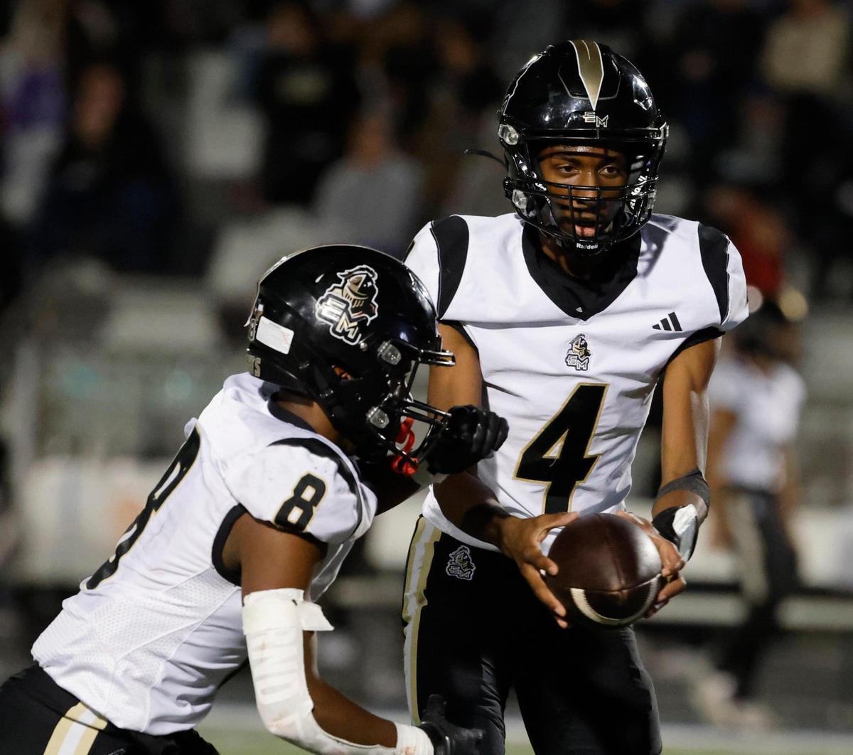 Eagle Mountain quarterback Cameron Henderson (4) hands the ball to running back Terry Starks (8) during an UIL 4A D2 Region 1 Bi-district football playoff game at Kangaroo Stadium in Weatherford, Texas, Friday, Nov. 15, 2024.