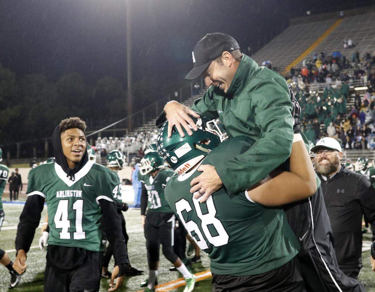 Arlington offensive lineman Max Castillo (68) lifts Arlington head coach Scott Peach into the air after their win of a high school football game at Maverick Stadium in Arlington, Texas, Thursday, Nov. 08, 2018. Arlington secured the District 4-6A with a 42-31 defeat of Arlington Lamar. (Special to the Star-Telegram Bob Booth)