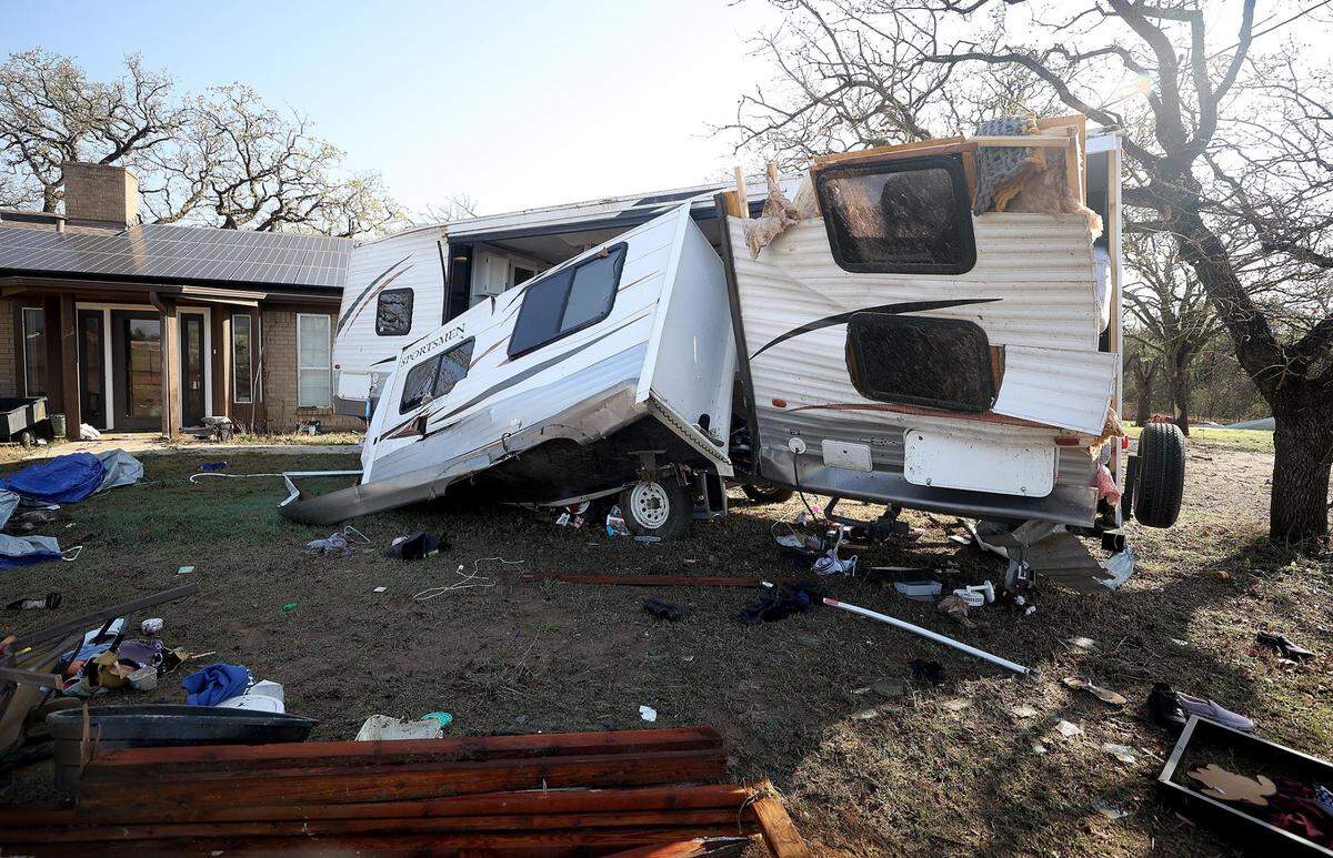 Debris is left in the yard of Shawn and Amber Zeleny’s Johnson County home after a tornado moved through on Monday night. Shawn was injured when a travel trailer flipped on top of him while he was helping his daughter get out.