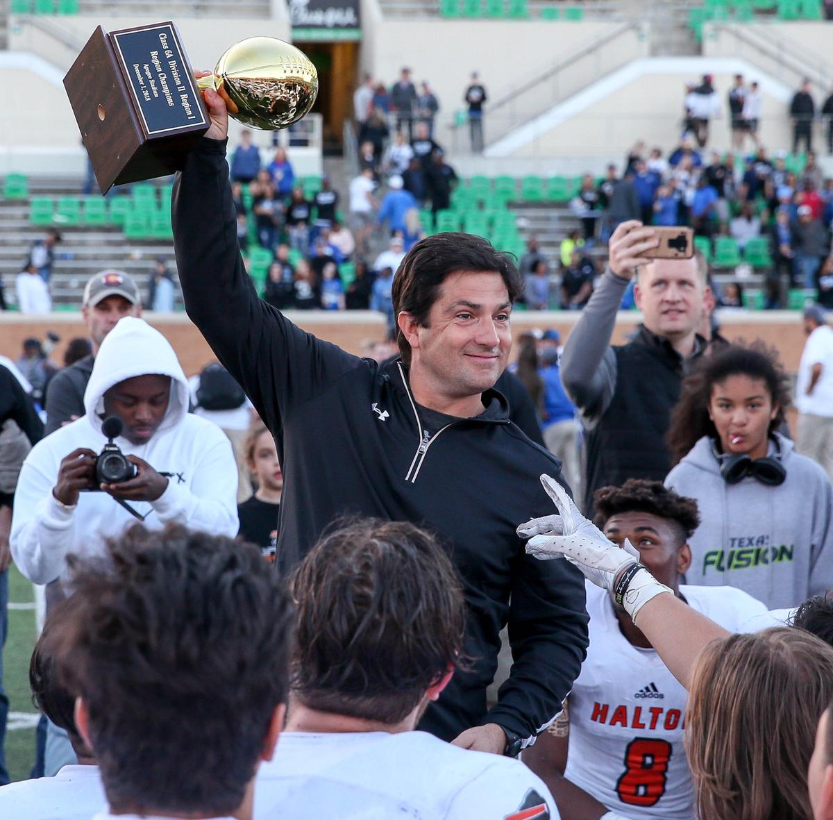 Haltom head coach Jason Tucker holds up the trophy after beating Hebron, 41-30, Saturday afternoon, December 1, 2018 in the 6A Division II regional playoff game played at Apogee Stadium in Denton, TX.
