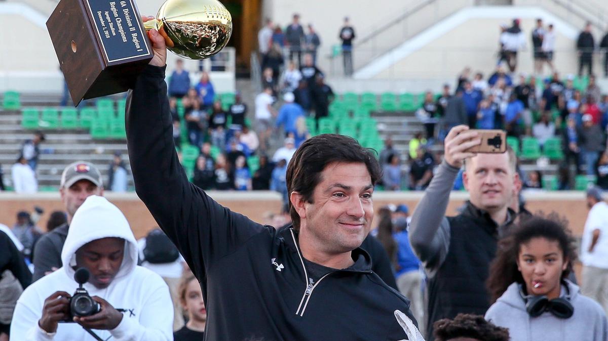 Haltom head coach Jason Tucker holds up the trophy after beating Hebron, 41-30, Saturday afternoon, December 1, 2018 in the 6A Division II regional playoff game played at Apogee Stadium in Denton, TX.