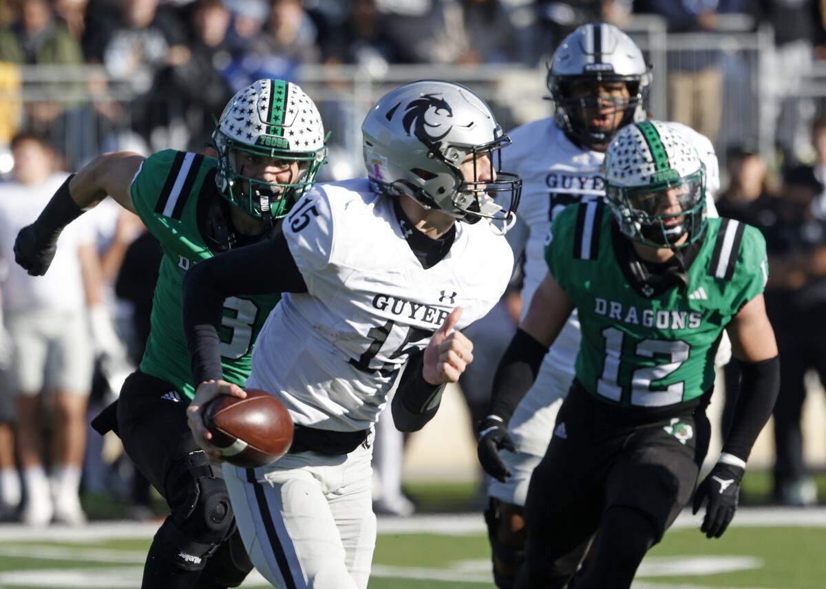 Denton Guyer quarterback Carter Morgan (15) scrambles away from Southlake Carroll defensive lineman Zac Hays (8) and linebacker Marcus Brouse (12) during the first half of a UIL Class 6A Division II Quarterfinal on Saturday Dec. 06, 2025 at Crowley ISD Multi-Purpose Stadium in Fort Worth, Texas.