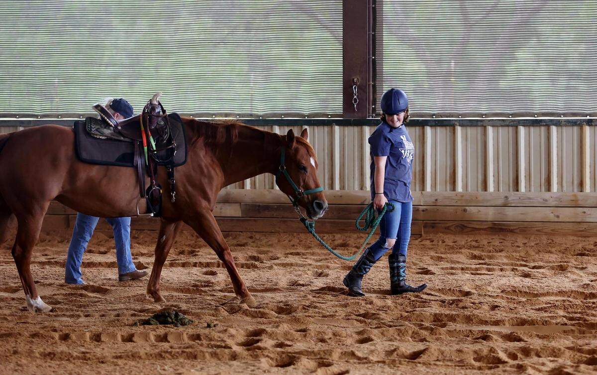 Gracie Alansard leads JJ in a circuit around the arena during her session at Wings of Hope Equitherapy on Monday, May 9, 2022, in Cleburne. Wings of Hope provides equine-assisted therapy to help people with disabilities, trauma, mental health issues, and terminal illness.