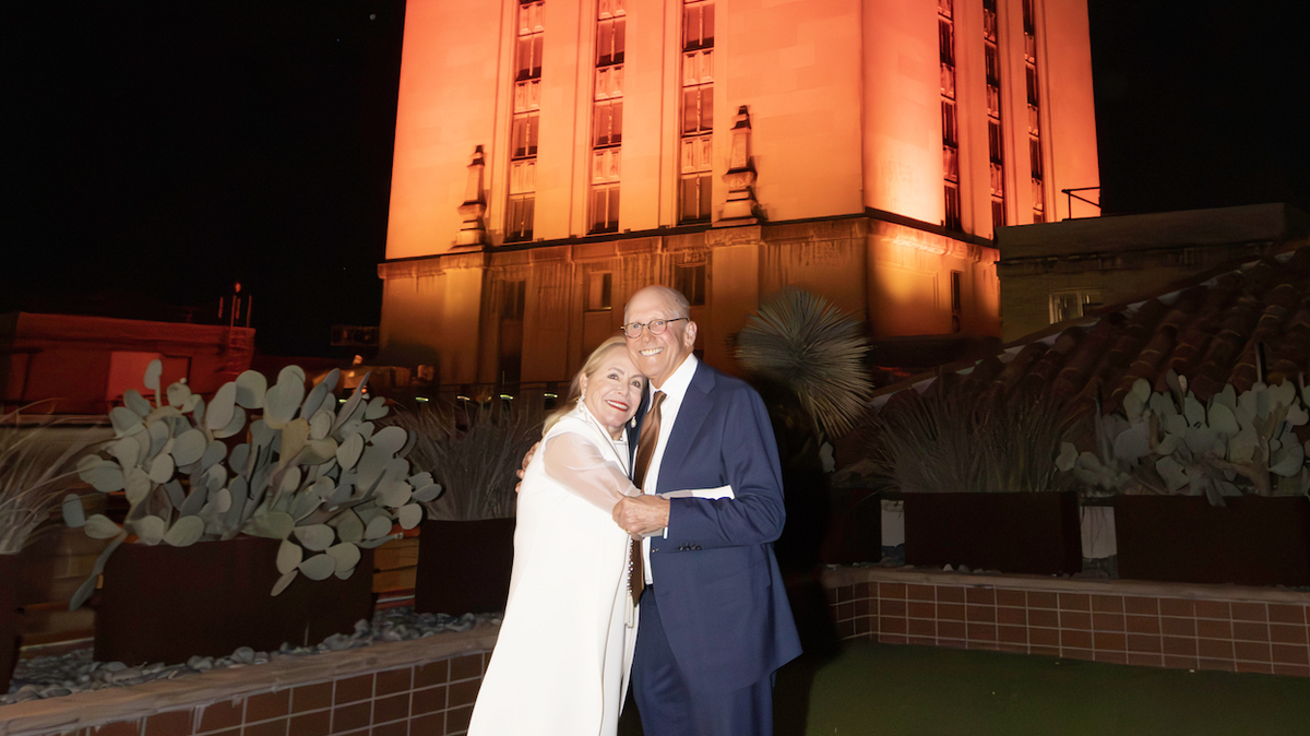 Rozanne Rosenthal and Billy Rosenthal pose in front of the UT Tower, which was lit in their honor Jan. 16, 2024, in recognition of their $25 million gift to the McCombs School of Business.