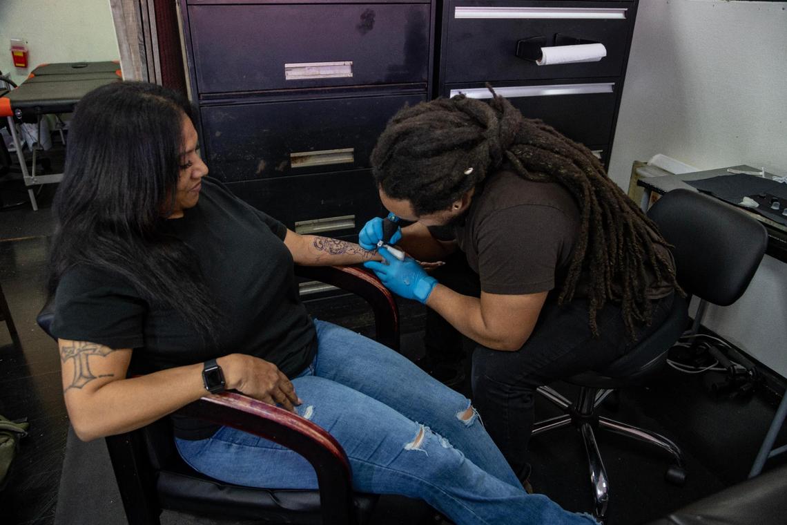 Tattoo artist Pharoah tattoos client Peggy Oquendo at Da Kandy Shop Tattoo Studio on Saturday, March 25, 2023.