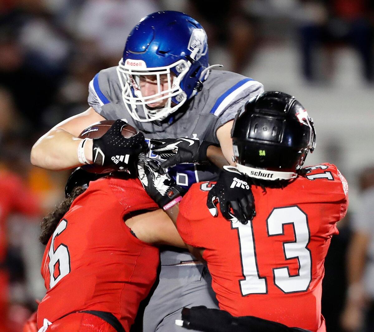 Weatherford tight end Hayden Hansen (89) is held up by Trinity linebacker Nai Mose (6) and defensive back Jacob Schaeffer (13) in a District 3-6A high school football game at Kangaroo Stadium in Weatherford, Texas, Friday Oct. 22, 2021. Trinity defeated Weatherford 49-21. (Special to the Star-Telegram Bob Booth)
