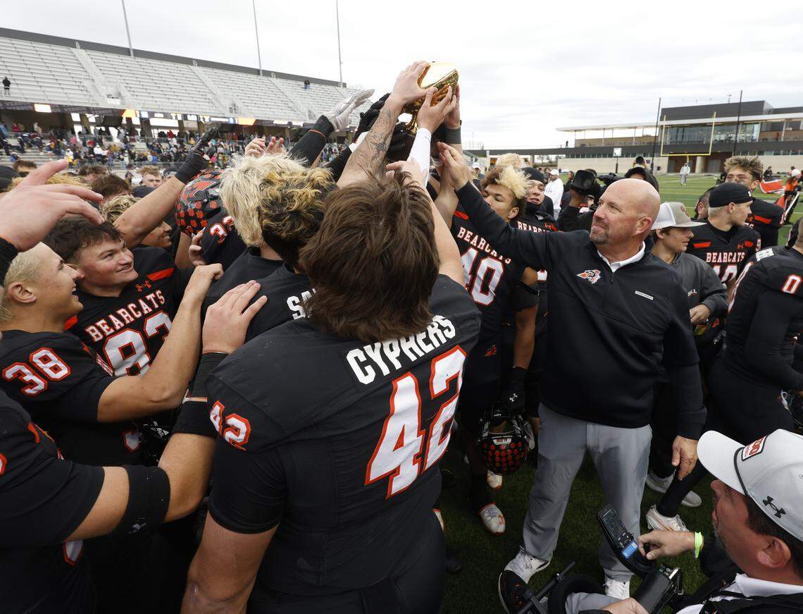 Aledo head coach Robby Jones hands the trophy to the Bearcats after defeating Fort Worth Arlington Heights in the UIL Class 5A Division I Regional on Friday Nov. 28, 2025 at Crowley ISD Multi-Purpose Stadium in Fort Worth, Texas.
