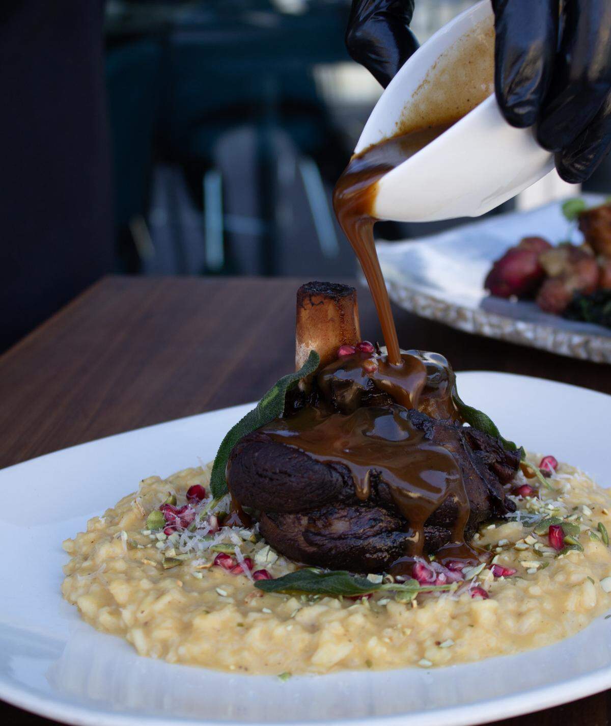 The Osso Bucco at Cafe Modern gets drenched tableside with a red wine pomegranate jus.