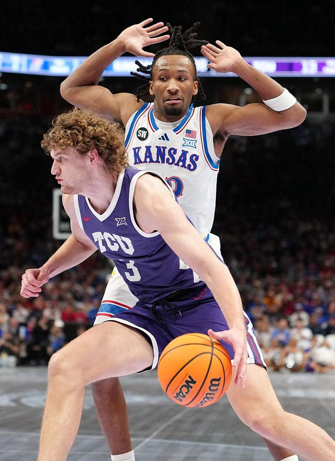 KANSAS CITY, MISSOURI - MARCH 12: Liutauras Lelevicius #3 of the TCU Horned Frogs drives around Darryn Peterson #22 of the Kansas Jayhawks in the first half during the quarterfinals of the Big 12 Tournament at T-Mobile Center on March 12, 2026 in Kansas City, Missouri. (Photo by Ed Zurga/Getty Images)