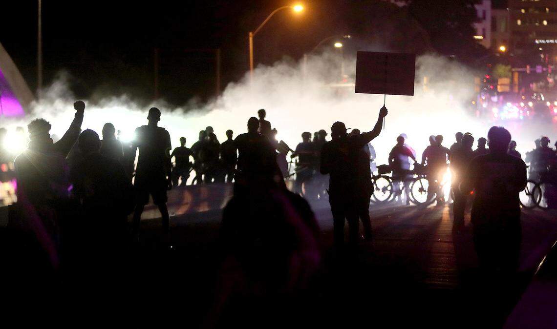 The Fort Worth police disperse a crowd protesting on the West 7th Street bridge with dispersal smoke, flash-bangs and tear gas on Sunday, May 31, 2020.