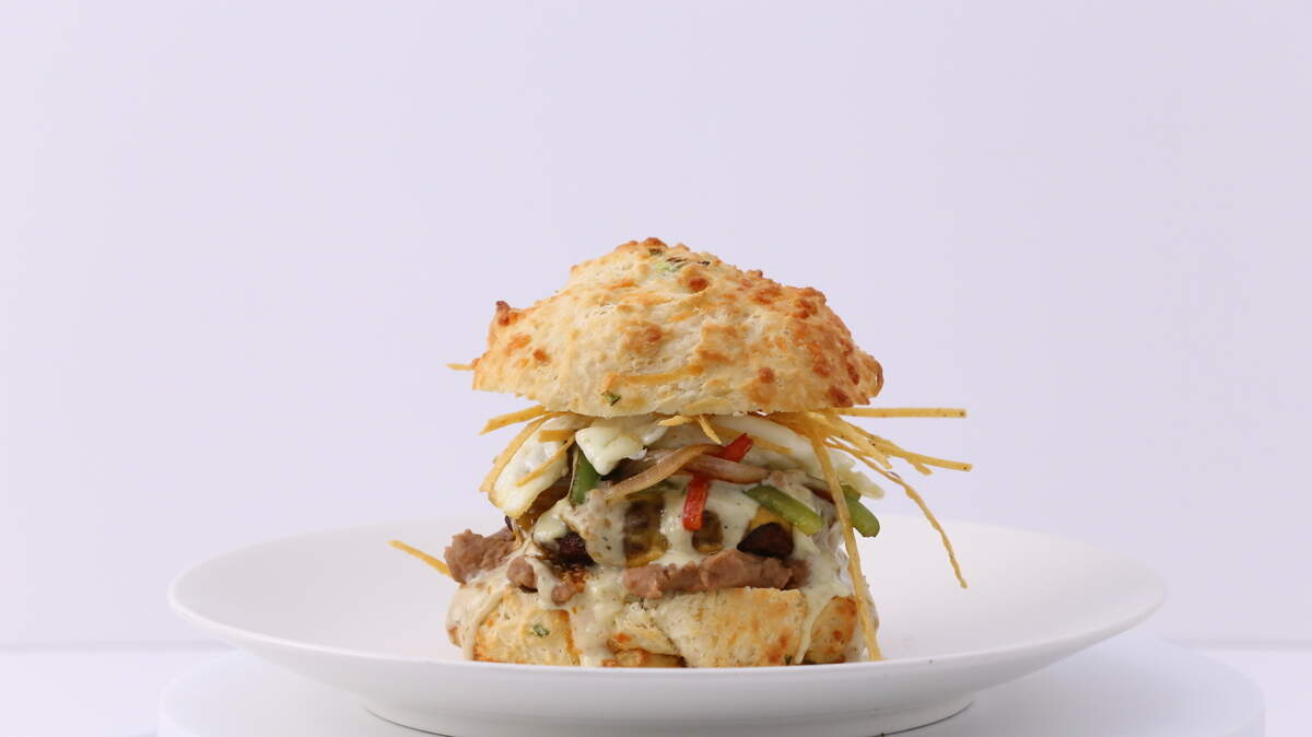 The Spanish Harlem sandwich at Stacks Biscuit House has refried beans, house pork chorizo, sunny side egg, crisp tortilla strips, peppers, onions, cheddar cheese, & bacon jalapeño gravy on a jalapeño cheddar biscuit.