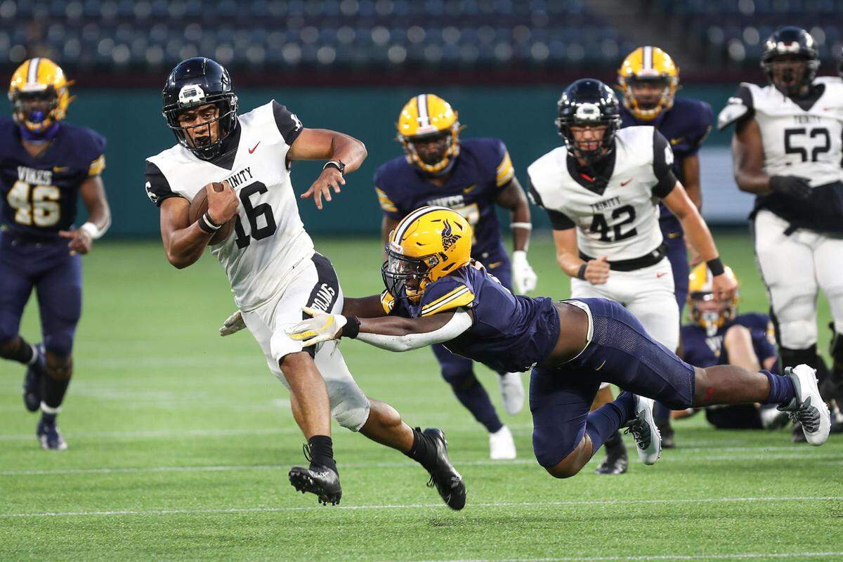 Arlington Lamar offensive lineman James Grando reaches out for Euless Trinity quarterback Valentino Foni as he runs the ball on Thursday, September 24, 2020, at Globe Life Park.