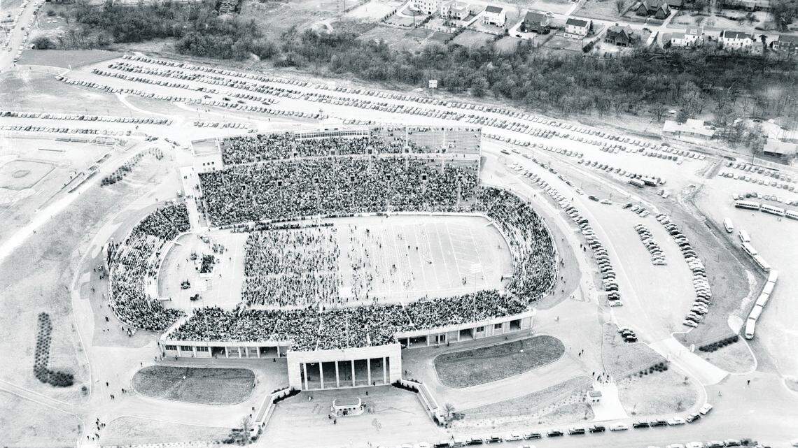 Billy Graham archive photo dated March 25, 1951, credit Special Collections Division-University of Texas at Arlington.  Evangelist Billy Graham, who has set attendance records throughout the country, set a new one for religious meetings in Fort Worth Sunday in Amon Carter stadium when an estimated 36,000 heard his final talk.  The crowd began arriving four hours before his sermon and left streets for blocks around the stadium lined with cars.  An hour and a half after the meeting closed, cars were still filing from the stadium area.  White dots on the field are pillows supplied by the revival committee for people to sit on during the service.